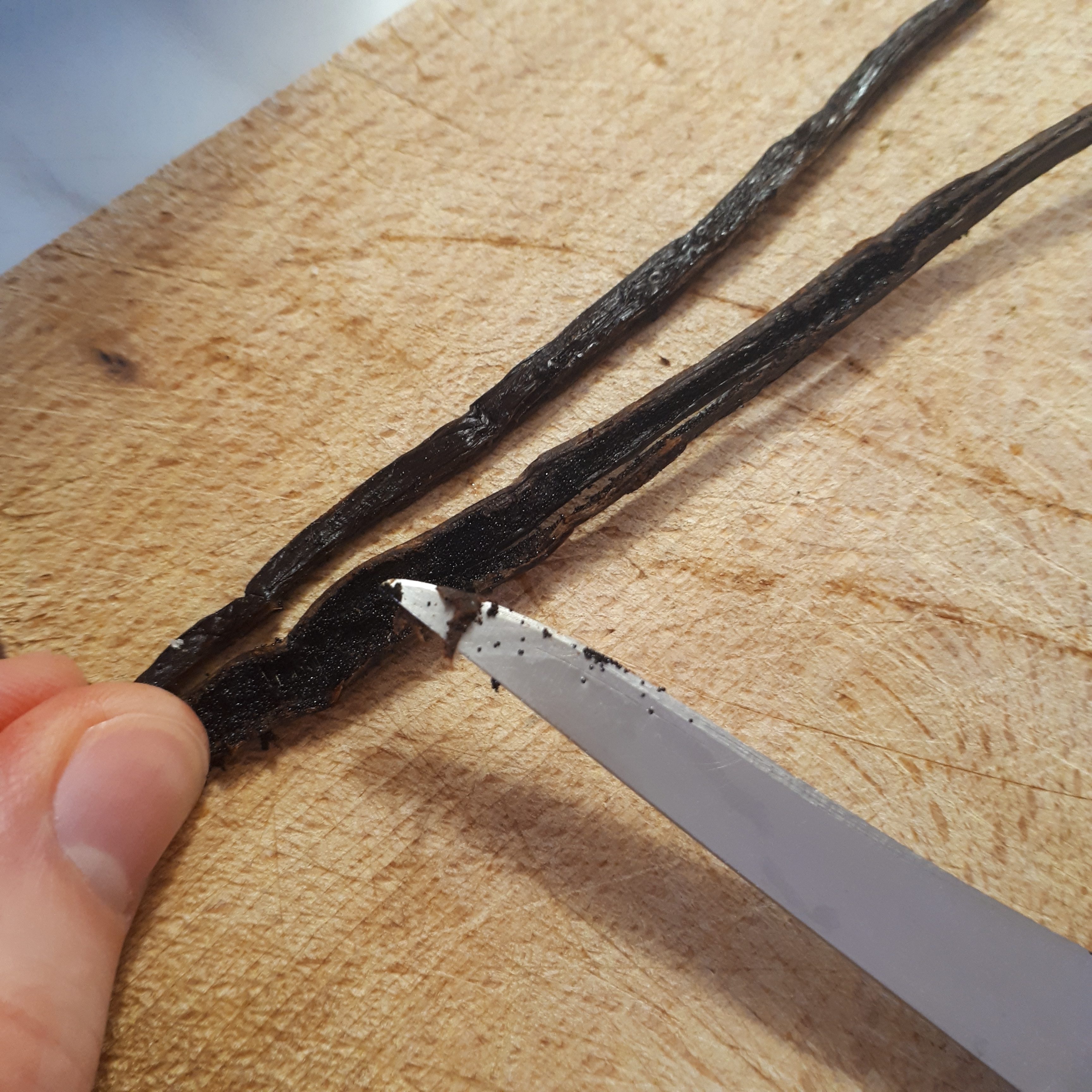Vyškriabané semienka z vanilkového struku drevená doska nôž