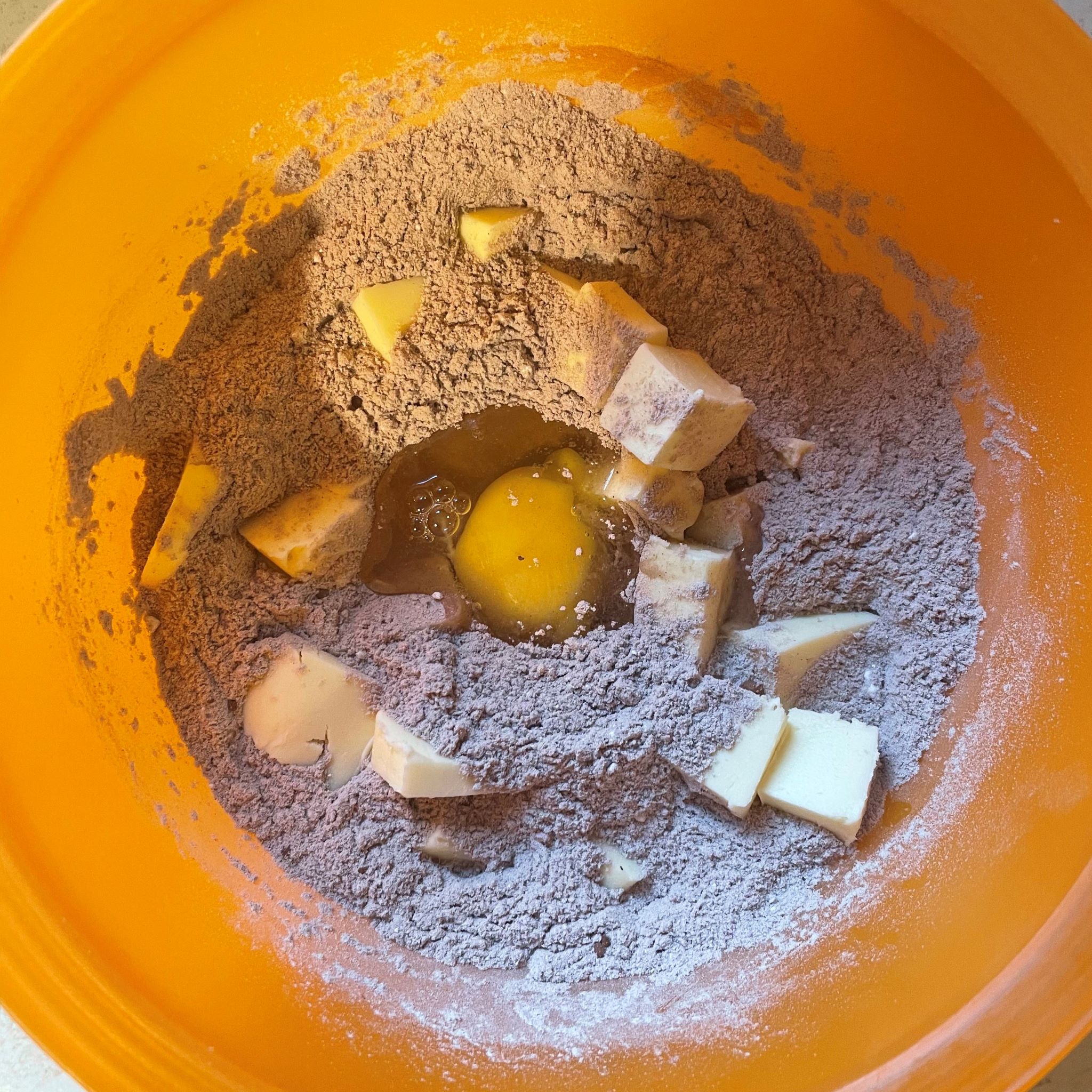 Oranžová misa s múkou kakaom maslom a vajíčkom
